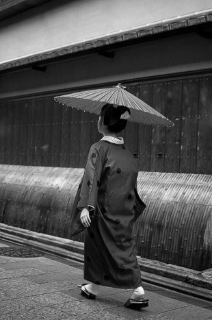 A geisha carrying a traditional umbrella (wagasa) on a rainy day in Miyagawa-chō, Kyōto.