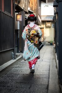 A geisha walking through one of the side streets of in Gion, Kyōto.